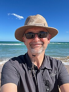 Mann Mit Hut Und Sonnenbrille Am Strand Bei Starker Sonneneinstrahlung Mann Mit Hut Und Sonnenbrille Am Strand Bei Starker Sonneneinstrahlung