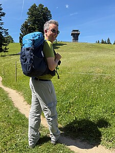 Wanderer Mit Rucksack In Der Mittagssonne Über Einer Bergwiese Im Allgäu Wanderer Mit Rucksack In Der Mittagssonne Über Einer Bergwiese Im Allgäu